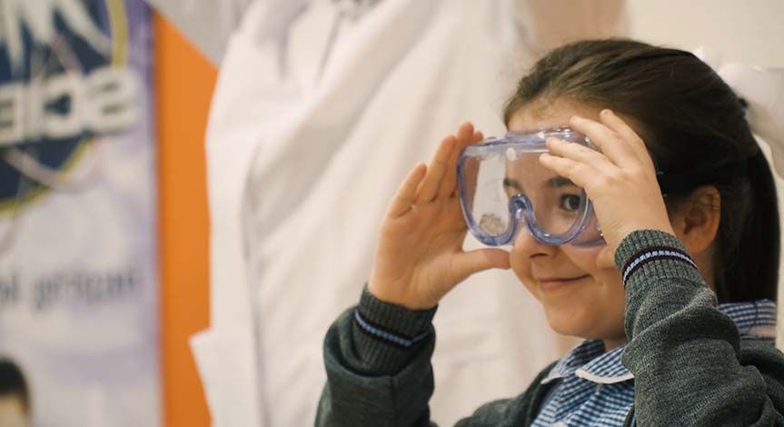 Girl smiling while wearing safety goggles